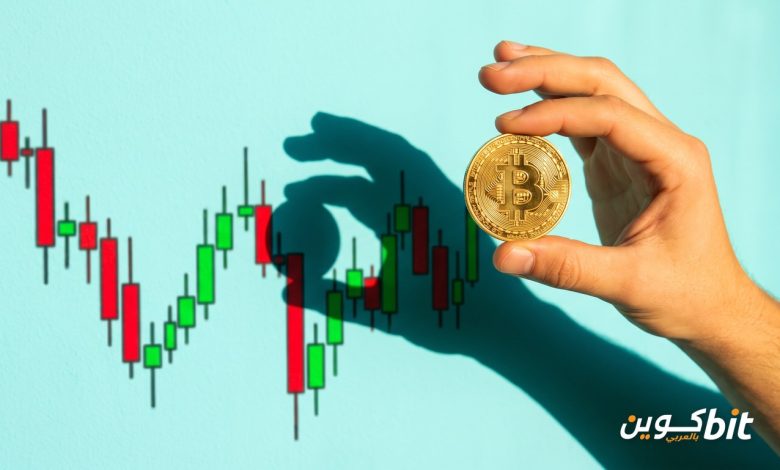 شراء البيتكوين أم عقود الفروقات: يد تمسك عملة بيتكوين ذهبية أمام رسم بياني بالشموع