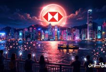 HSBC RedCoin: عملة حمراء وبيضاء تحمل شعار HSBC تشرق كالقمر فوق ميناء فيكتوريا في هونغ كونغ